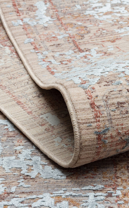 Load image 1 in gallery view. Beige and rust-colored rug with a distressed, faded traditional pattern and light blue accents, shown folded.