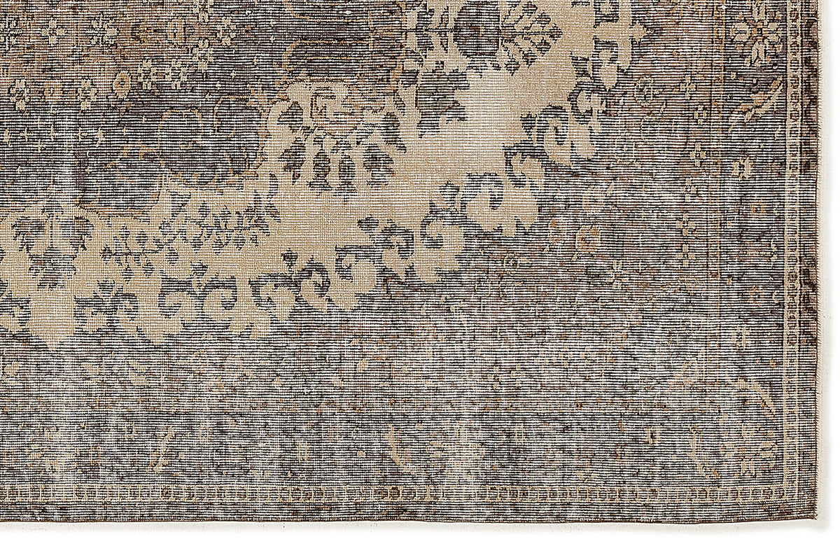 Charcoal and beige rug with a distressed, traditional floral medallion pattern and a linear textured weave.