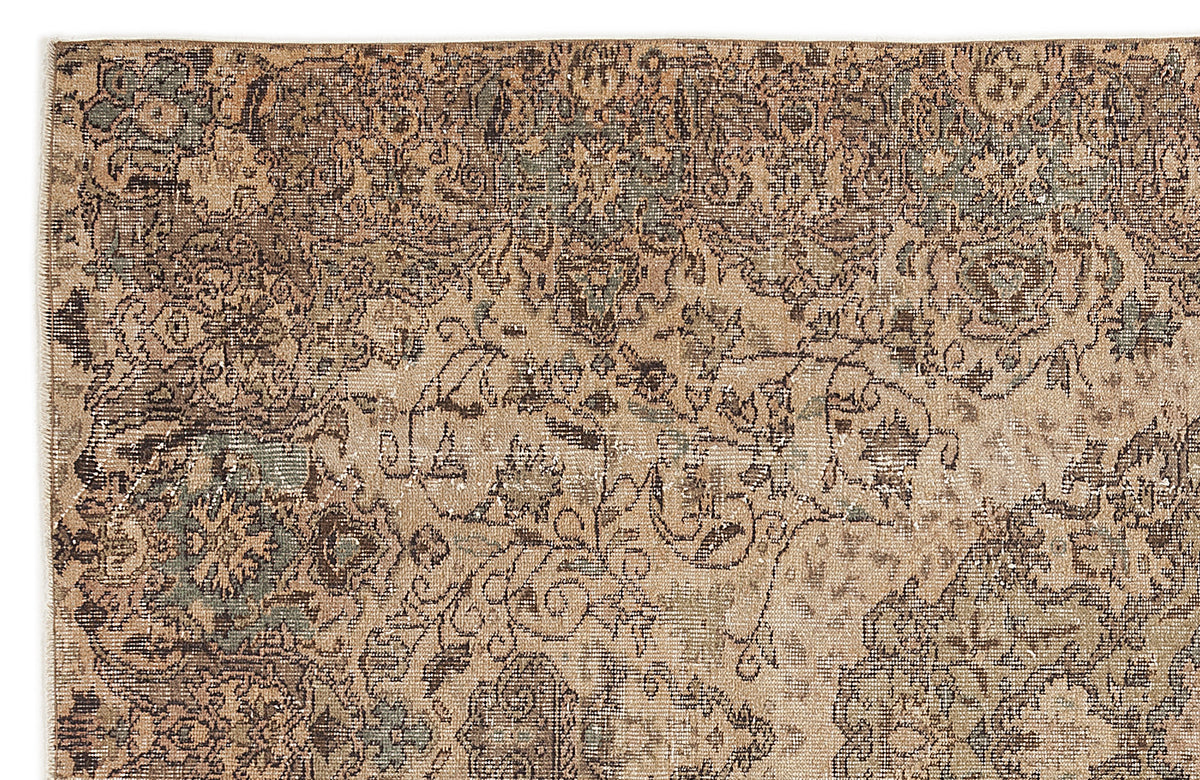 Distressed tan, brown, and muted sage green rug with a traditional faded floral medallion pattern.