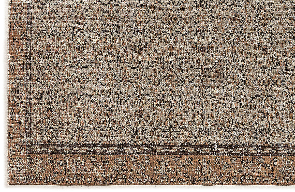 Beige and brown rug with a distressed, intricate geometric pattern and a wide, ornate border.
