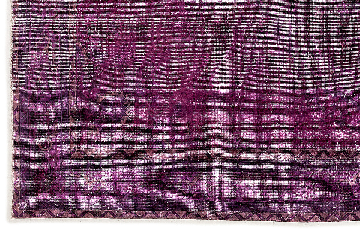 Deep purple vintage-style rug with a distressed floral medallion pattern and a geometric border.