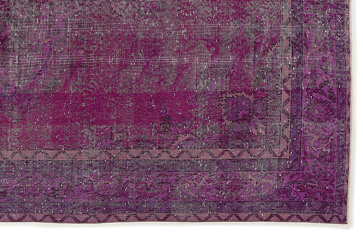 Deep purple distressed rug with a faded traditional medallion pattern and a geometric border.