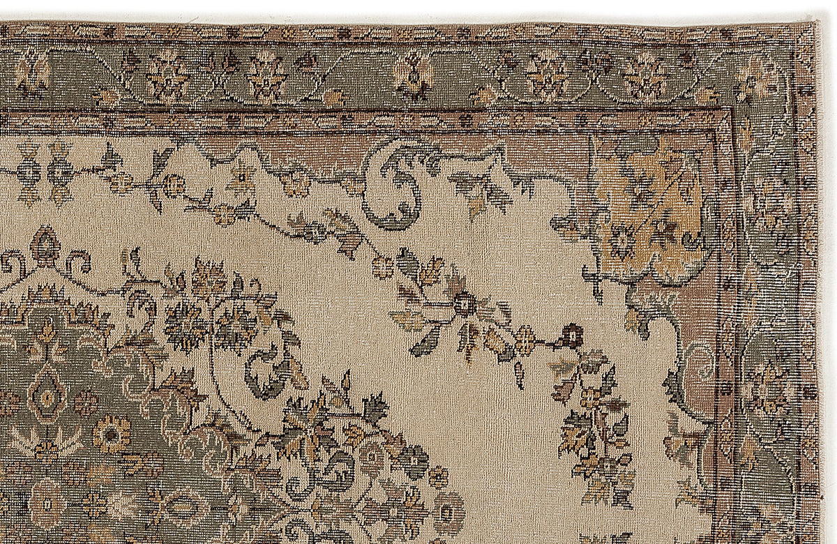 Beige, sage green, and brown traditional rug with a floral medallion and vine border pattern on a white background.
