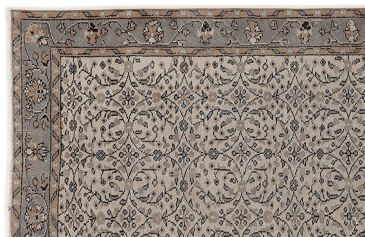 Beige and grey traditional rug with a repeating floral medallion pattern and a decorative border.