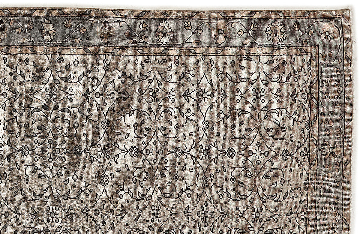 Grey and beige traditional rug with a repeating floral lattice pattern and a decorative border.