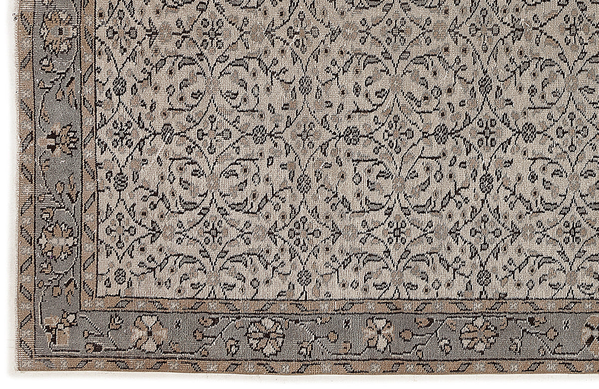 Beige and grey rug with a traditional floral trellis pattern and a decorative border.