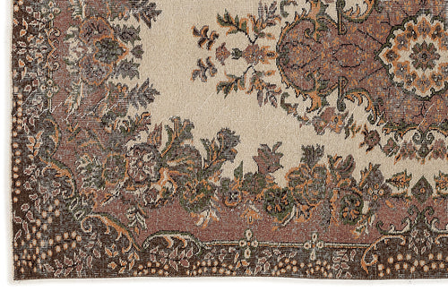 Load image 1 in gallery view. Beige rug with a distressed traditional floral medallion pattern in brown, olive green, and rust orange.