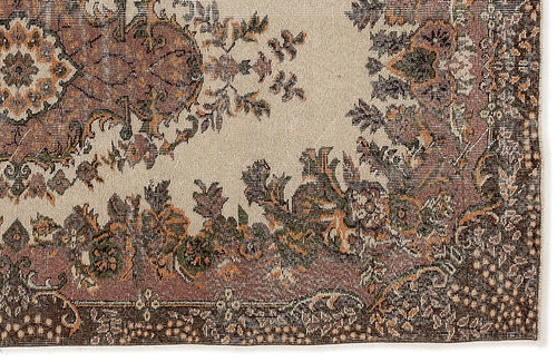 Load image 1 in gallery view. Beige rug with a distressed traditional floral medallion pattern in shades of brown, rust, and dark green.