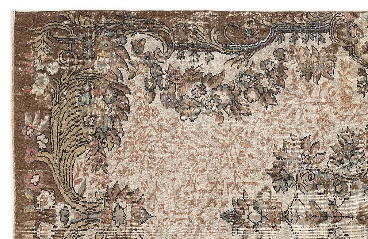 Brown and cream traditional rug with a distressed floral medallion pattern and ornate border.