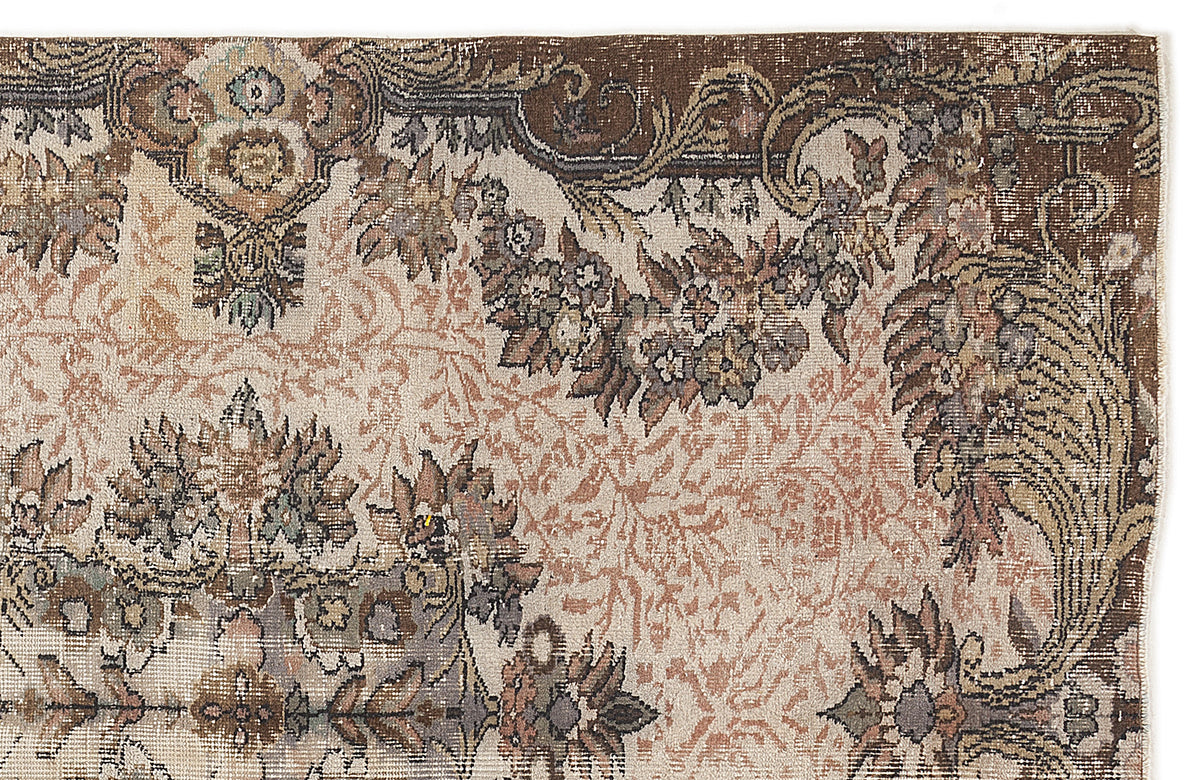 Distressed vintage-style rug with a brown, cream, and muted floral medallion pattern on a white background.