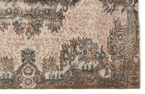 Load image 1 in gallery view. Distressed beige, brown, and muted terracotta rug with a traditional floral medallion and vine pattern.