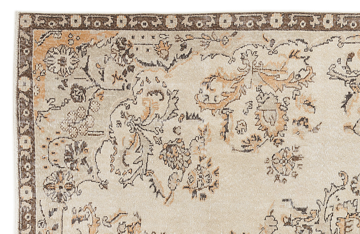 Beige rug with a dark brown and tan distressed floral pattern and a decorative border.