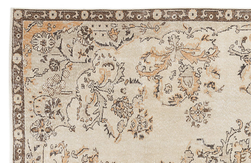 Load image 1 in gallery view. Beige rug with a dark brown and tan distressed floral pattern and a decorative border.