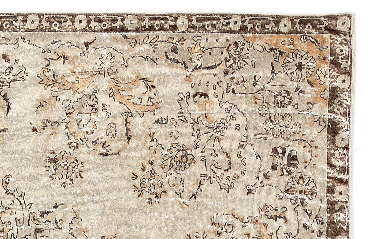 Beige and brown rug with a distressed floral medallion pattern and a dark brown geometric border.