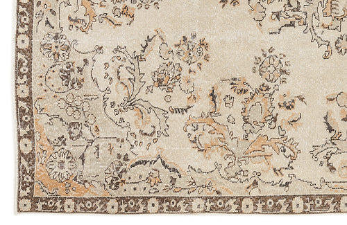 Load image 1 in gallery view. Beige rug with a distressed floral pattern in brown and tan, featuring a dark brown geometric border.