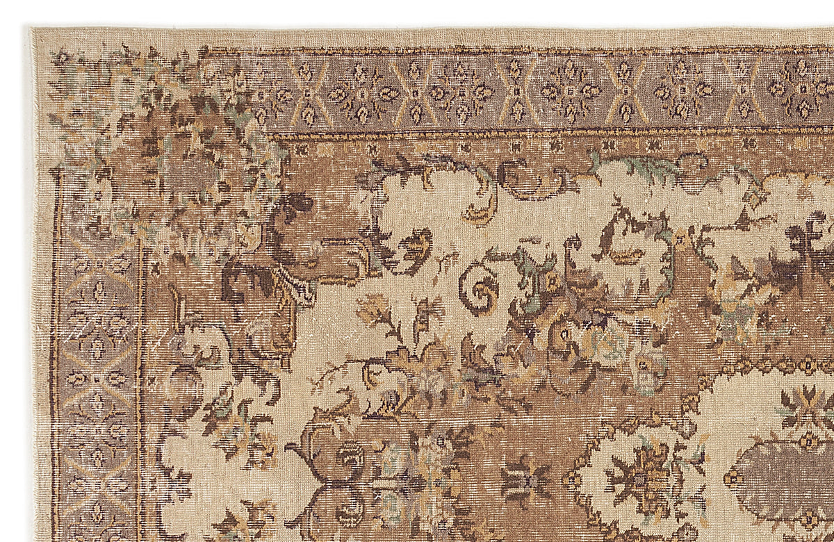 Beige and brown traditional rug with a distressed floral medallion pattern and a decorative geometric border.