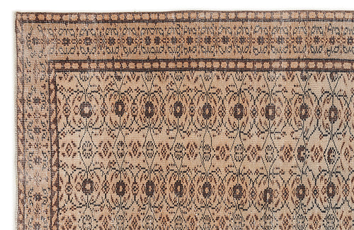 Load image 1 in gallery view. Tan and dark brown rug with a repeating geometric diamond and floral medallion pattern and a decorative border.