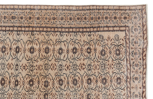 Load image 1 in gallery view. Tan and brown vintage-style rug with a dark floral medallion pattern and a geometric border on a white background.