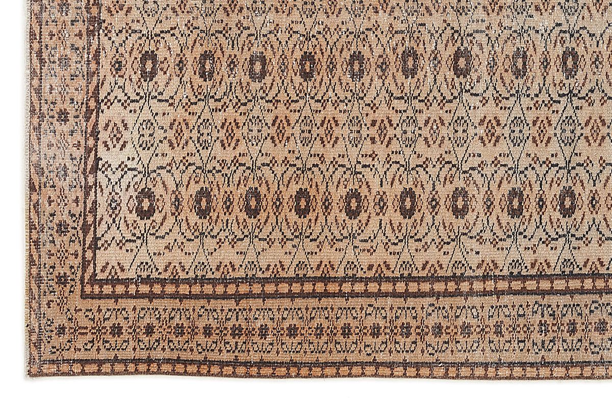 Tan and dark brown rug with a repeating geometric diamond pattern and a decorative border.