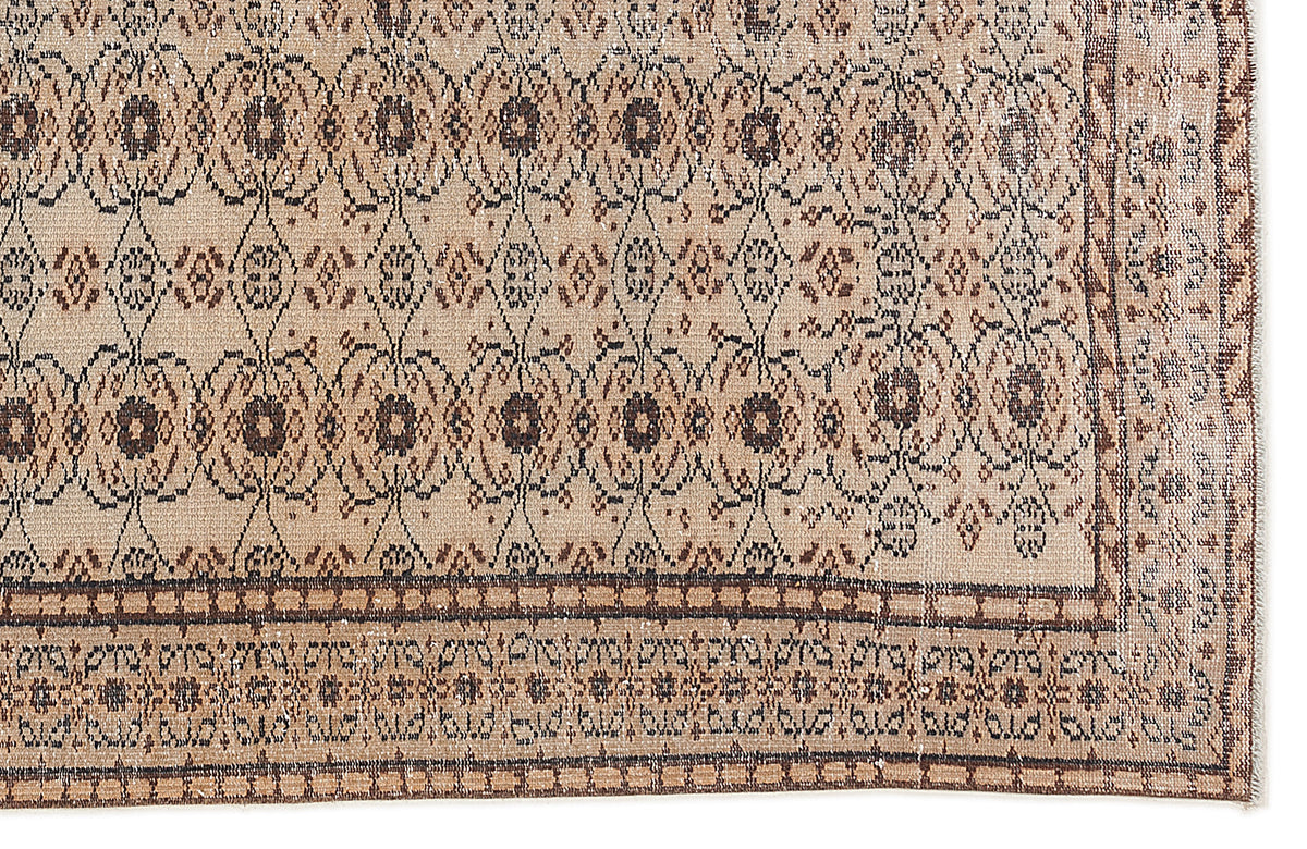 Tan and brown vintage-style rug with a repeating floral medallion pattern and a geometric border.