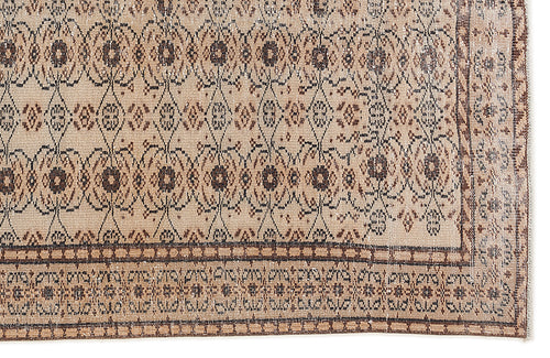 Load image 1 in gallery view. Tan and brown vintage-style rug with a repeating floral medallion pattern and a geometric border.