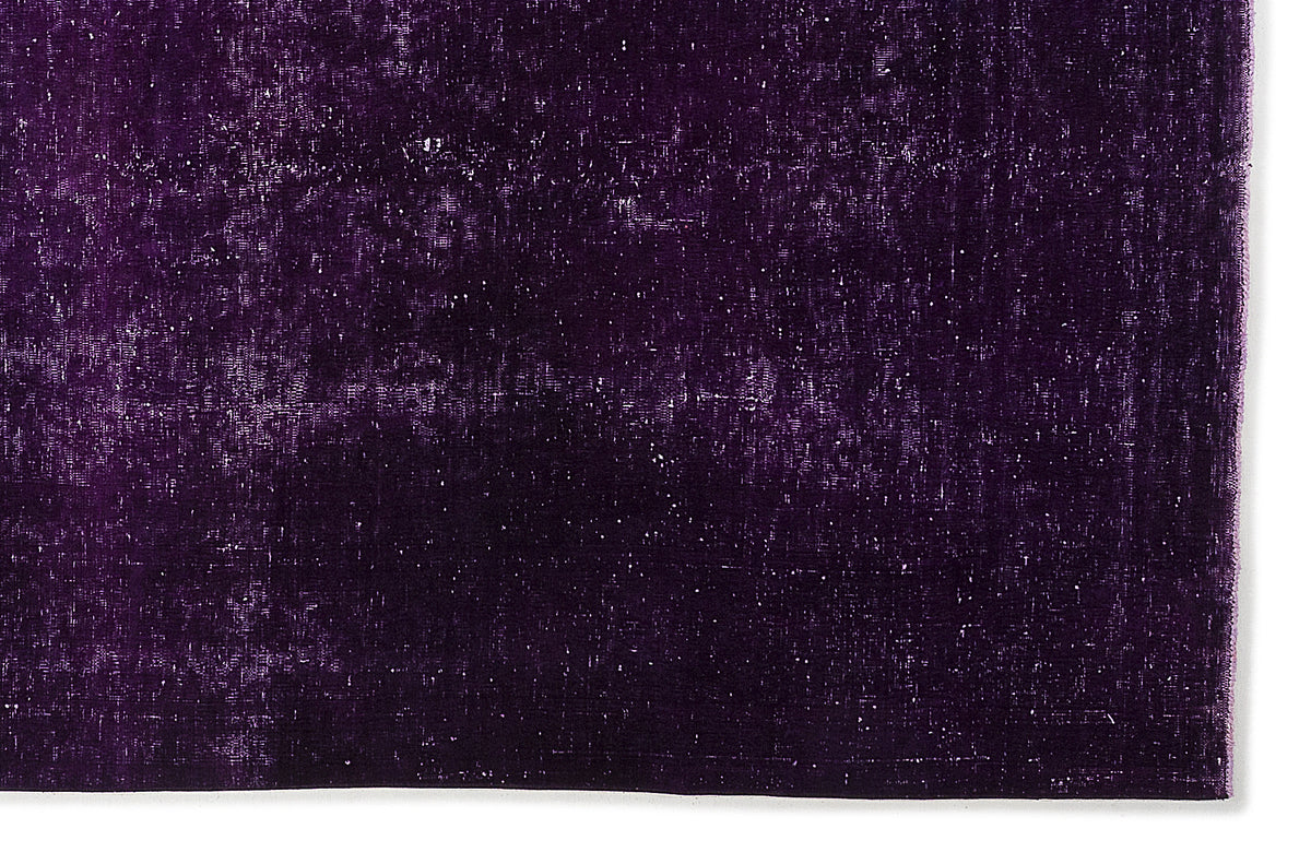 Deep purple rug with a distressed, weathered texture and subtle white flecks on a white background.