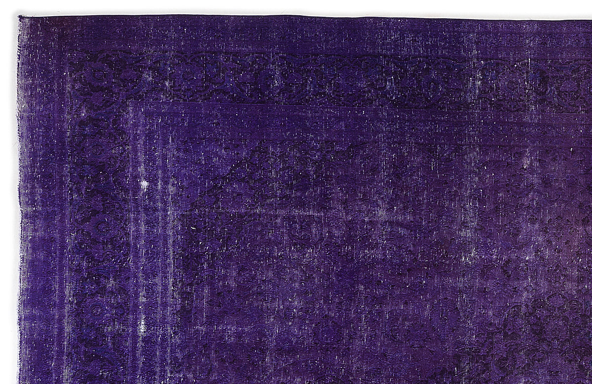 Deep purple vintage-style rug with a faded, distressed traditional border and central medallion pattern.