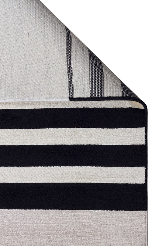 Bild 1 in Galerieansicht laden. Black and white striped rug with a folded corner revealing the textured backing.