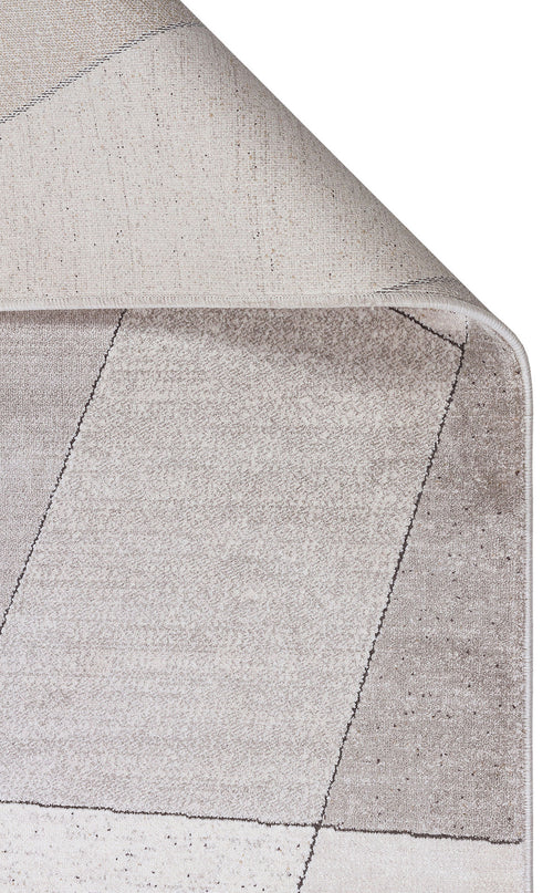 Bild 1 in Galerieansicht laden. Beige and cream area rug with a folded corner revealing a textured backing and a subtle geometric line pattern.