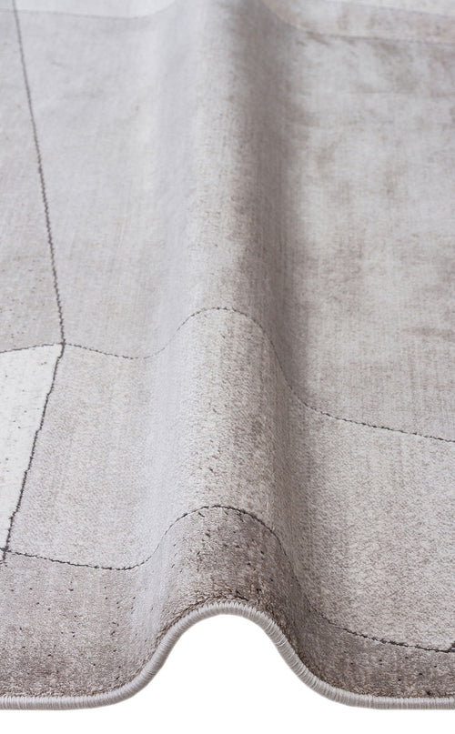 Bild 1 in Galerieansicht laden. Light gray rug with a subtle grid pattern and soft, distressed texture, shown in a folded close-up view.