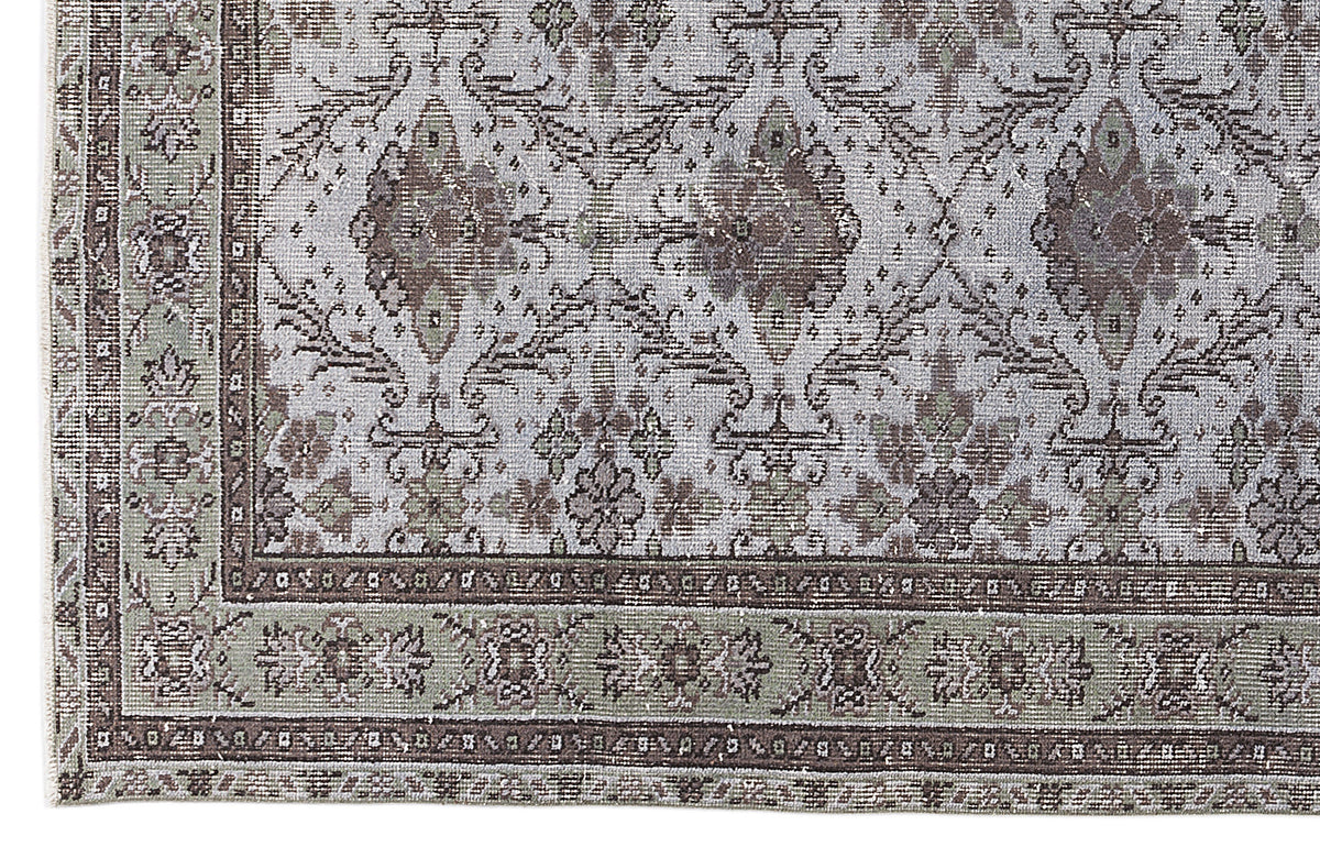 Grey and brown traditional rug with a distressed floral medallion pattern and a detailed border.