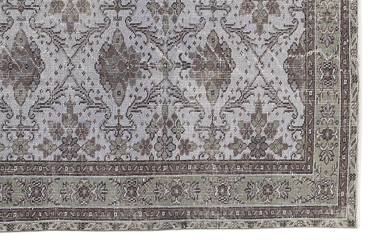 Distressed sage green and grey traditional rug with a faded floral medallion pattern and a detailed border.