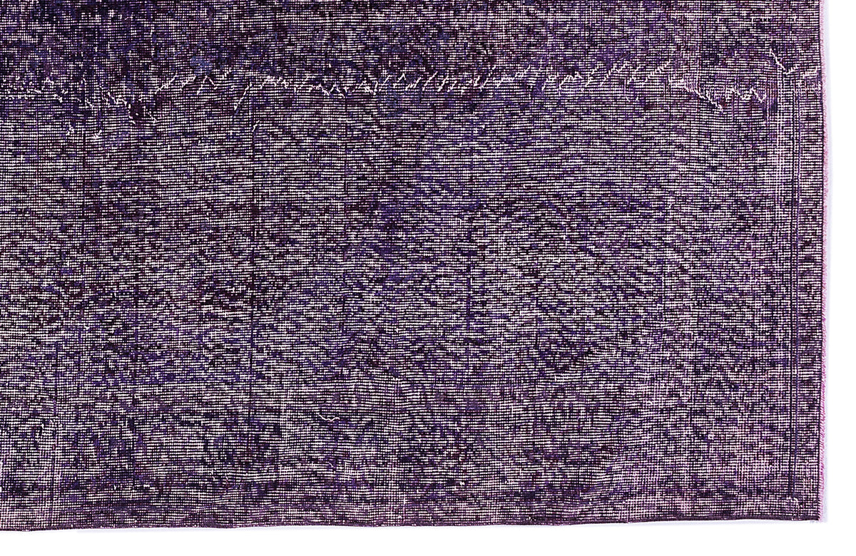 Deep purple distressed rug with a faded, traditional overdyed pattern and a visible border.