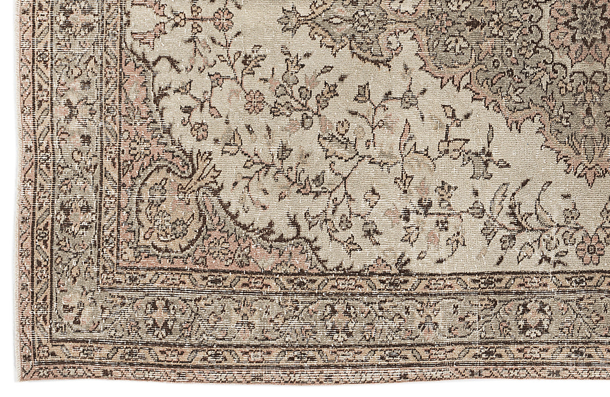 Beige and muted pink traditional rug with a distressed floral medallion pattern and a detailed geometric border.