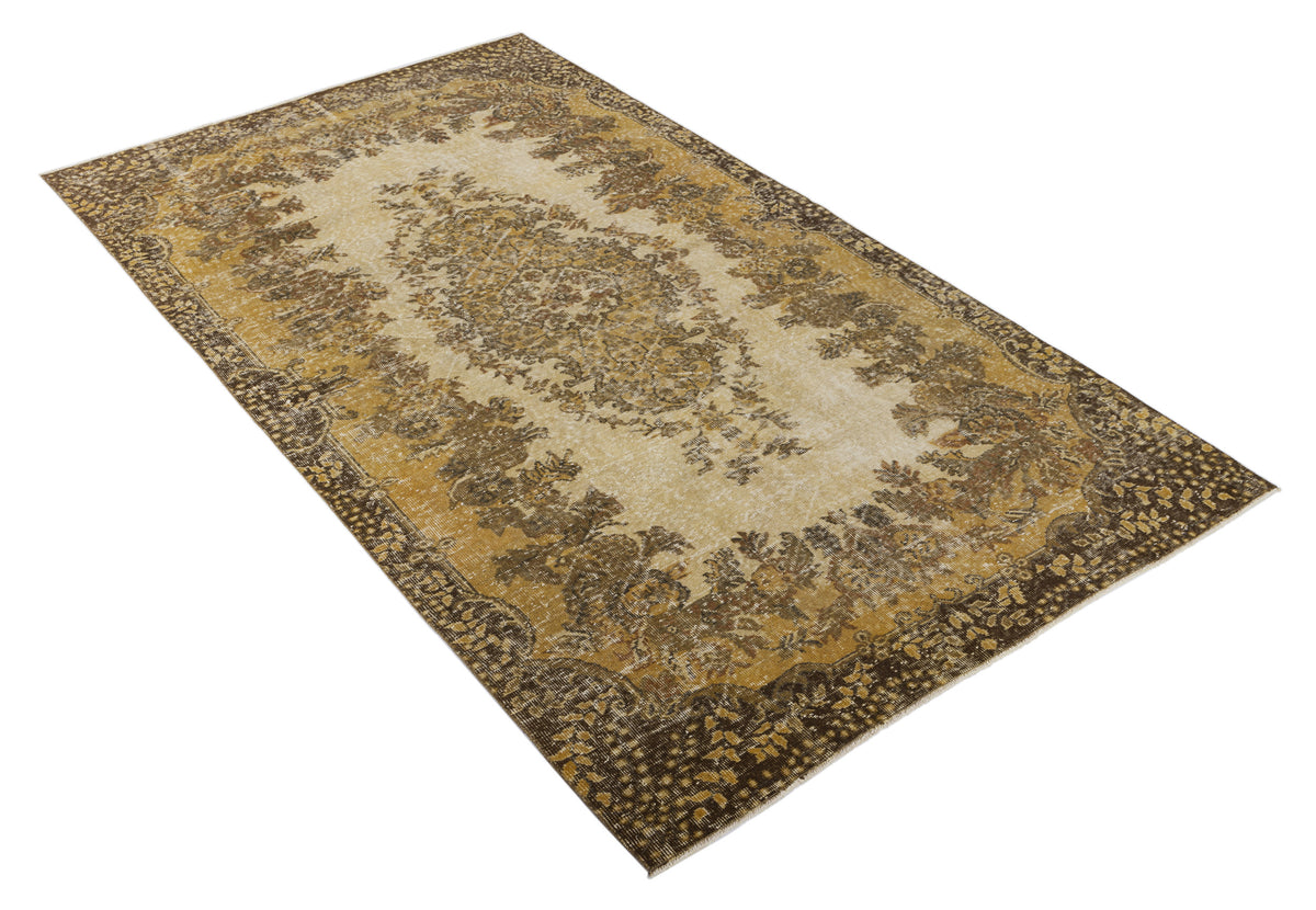 Distressed brown and cream traditional rug with a central floral medallion and ornate border on a white background.