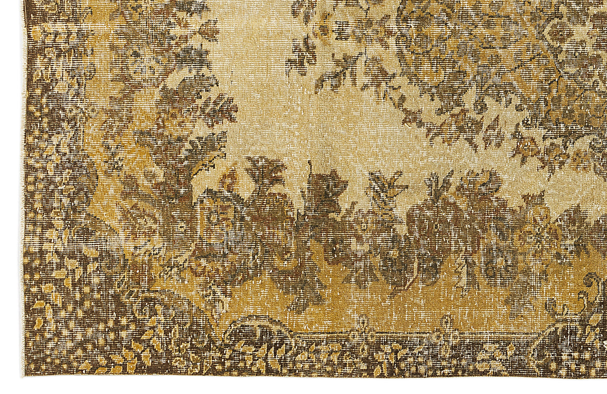 Gold and brown vintage-style rug with a distressed floral medallion pattern and a detailed border.