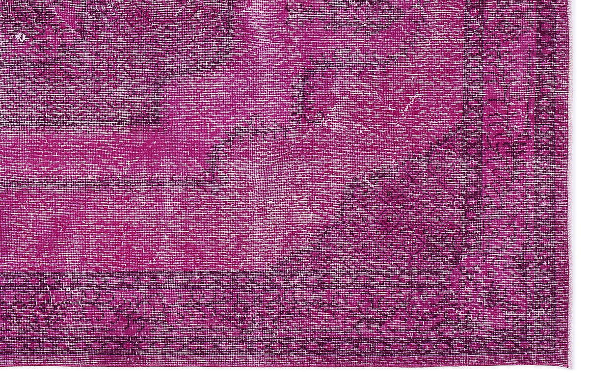 Magenta and dark purple distressed vintage-style rug with a traditional ornate border and faded medallion pattern.