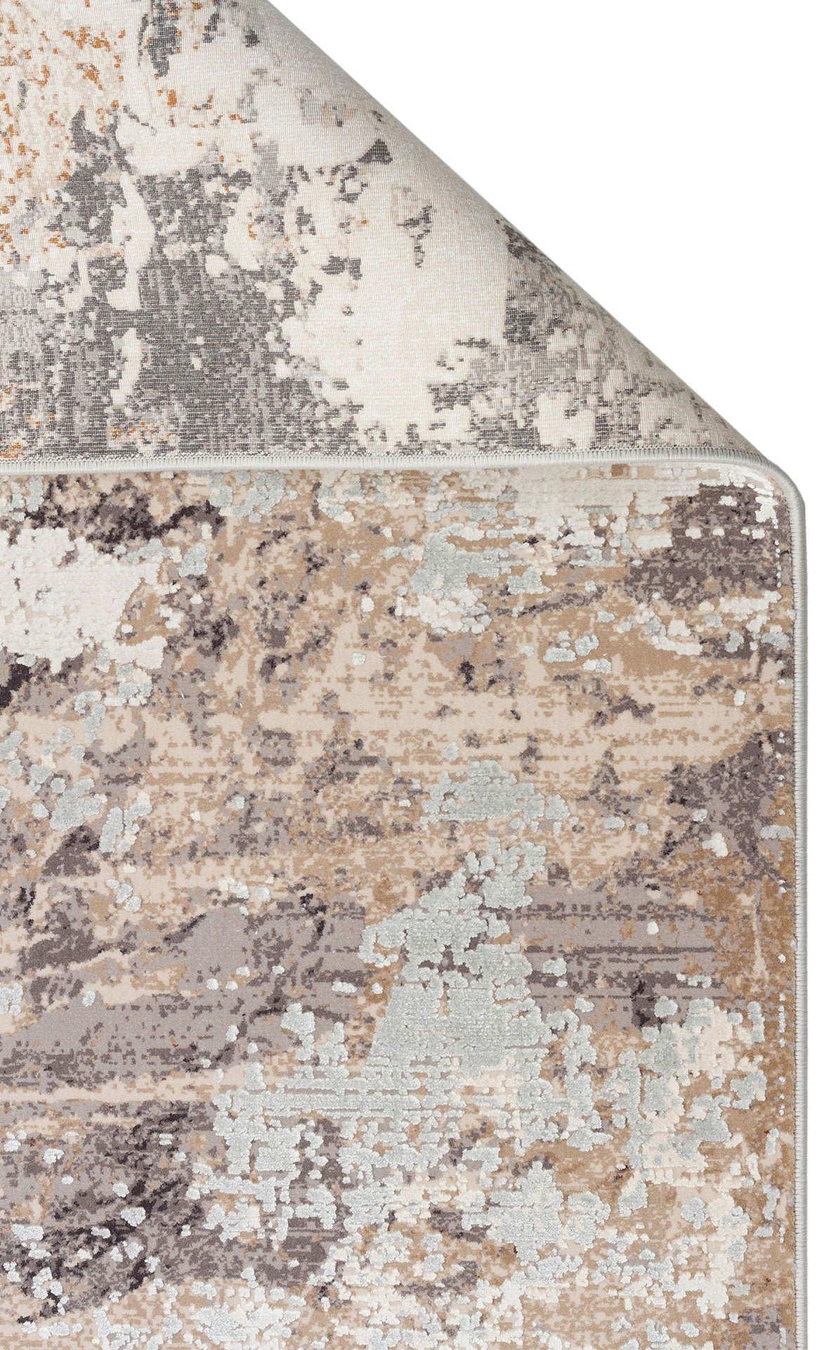Beige, grey, and white abstract distressed rug with a folded corner showing the backing on a white background.