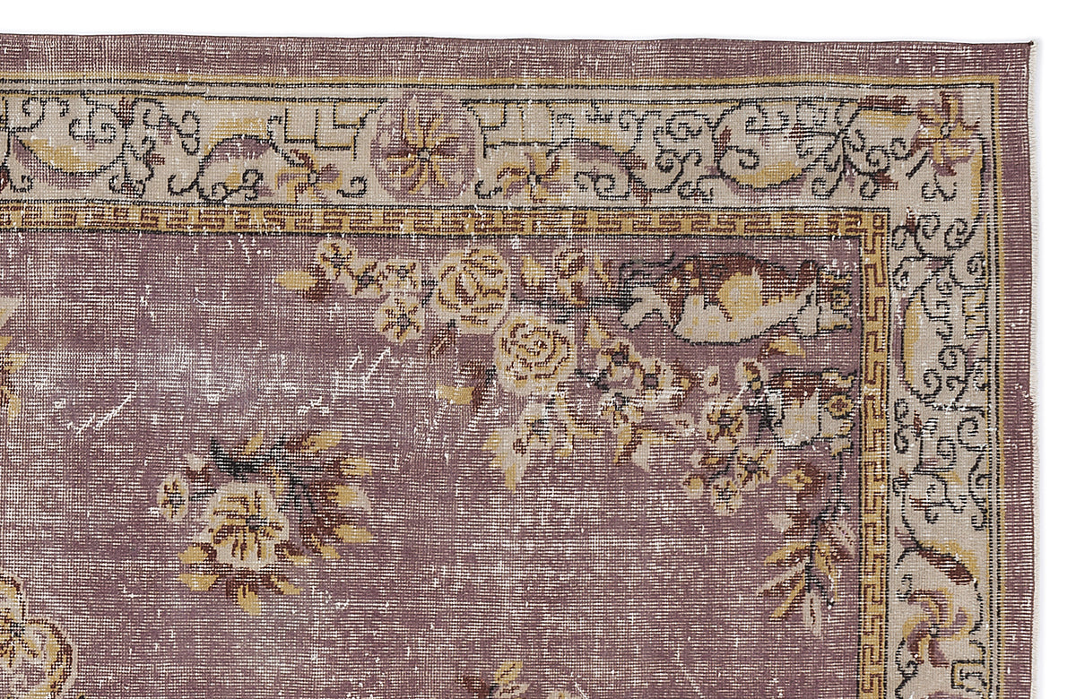 Distressed mauve rug with a cream and gold floral border and central botanical motifs on a white background.