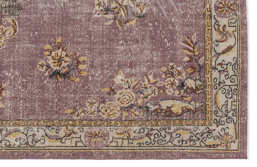 Load image 1 in gallery view. Distressed mauve rug with yellow and cream floral motifs and a geometric border pattern.