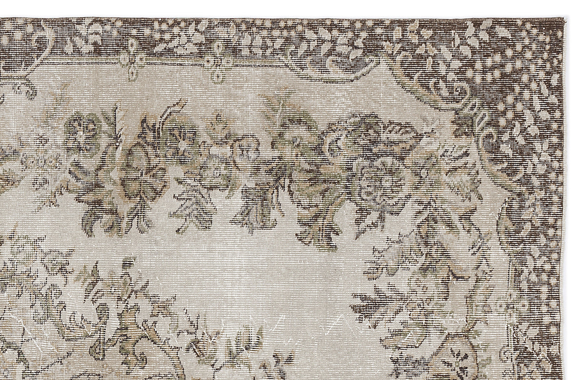 Beige and brown vintage-style rug with a distressed floral medallion pattern and a dark decorative border.