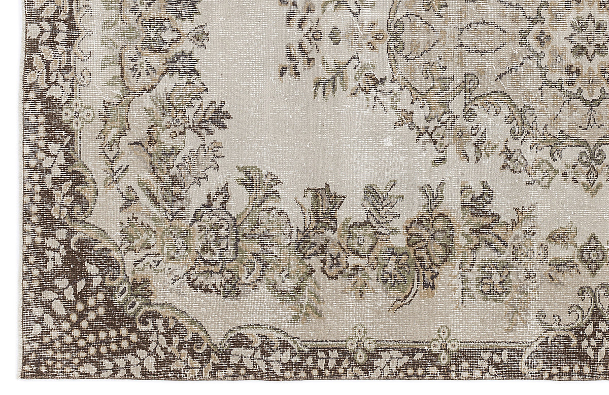Beige and brown distressed rug with a traditional floral medallion pattern and ornate border.