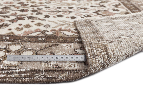 Load image 1 in gallery view. Beige and brown traditional patterned rug with a folded corner revealing the woven backing and a metal ruler for scale.