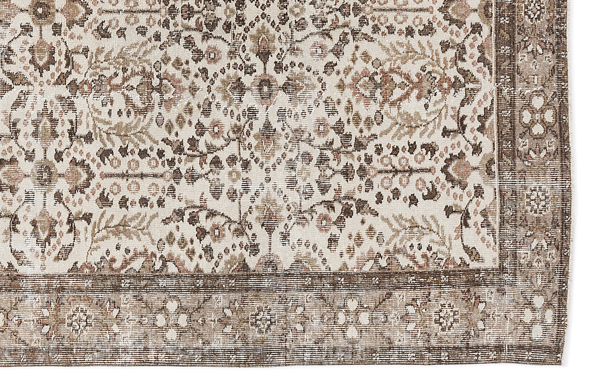 Cream, brown, and muted pink traditional rug with a distressed floral medallion pattern and a wide decorative border.