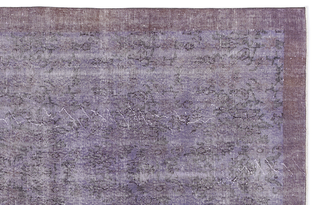 Distressed purple and charcoal rug with a faded, overdyed vintage pattern and a solid dark border.