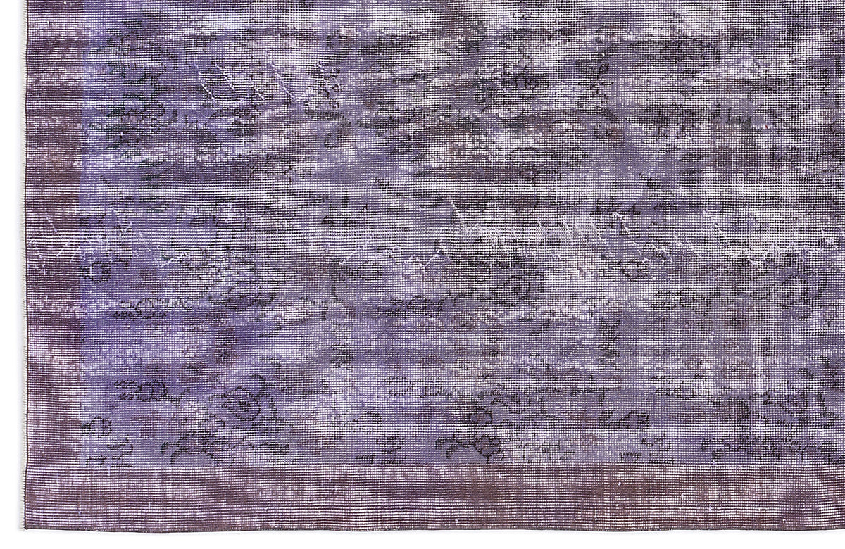 Purple and charcoal distressed vintage-style rug with a faded floral medallion pattern and a solid border.