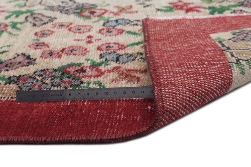 Load image 1 in gallery view. Beige rug with red, green, and grey floral pattern, folded to show the red underside and a metal ruler for scale.