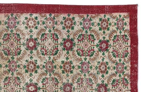 Load image 1 in gallery view. Distressed vintage rug with a red border and a repeating floral medallion pattern in red, green, and beige.