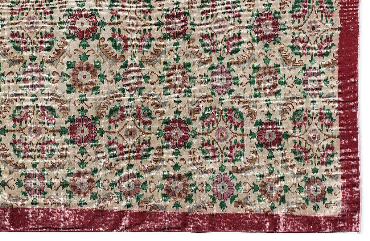 Beige rug with a repeating floral medallion pattern in red, green, and tan, featuring a solid red border.