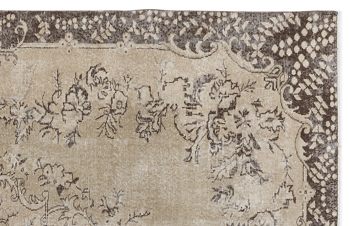 Beige and dark brown vintage-style rug with a distressed floral pattern and a decorative border.